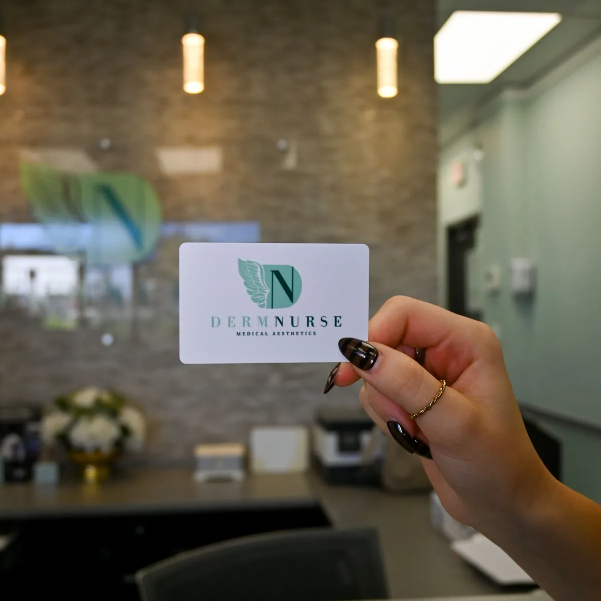 A DermNurse membership card held up at the front desk